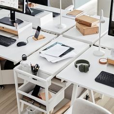 an office desk with two computer monitors, keyboard and headphones on top of it