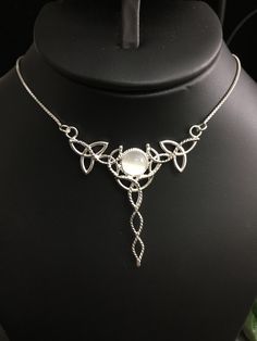 "I've fabricated a Celtic Knot inspired, statement necklace to which is perfect for a wedding, or hand fasting, or even a Renaissance event, with sterling silver Trinity Knots woven into a necklace and featuring an 8mm glowing genuine White Moonstone, or your choice from the drop down menu. The motif of the pendant is designed with a total of 5 Trinity Knots and sterling wire work braids down the center to add the balancing touches to the piece. It comes with a 16 inch sterling silver box chain White Moon Phase Necklace For Wedding, Moon Phase Round Pendant Necklace For Wedding, Wedding Necklaces With Moon Phase Round Pendant, Handmade Spiritual Necklaces For Wedding, Spiritual Handmade Necklaces For Wedding, Handmade Spiritual Necklace For Wedding, Round Moon Phase Necklaces For Weddings, Moon Phase Round Necklaces For Weddings, Bohemian Round Bridal Necklace As Gift