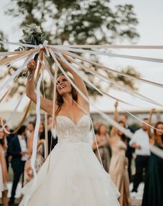 a woman in a wedding dress holding up ribbons