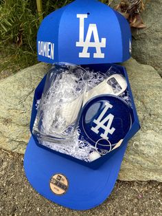 a los angeles dodgers hat and other items are in an ice bucket on the ground