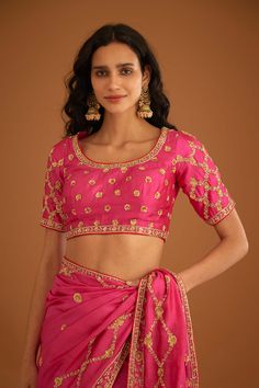 Editor's Note A fuschia pink zardozi embroidered dupion silk sari and blouse would be a stunning and bold choice for a formal occasion. The rich and luxurious fabric of the dupion silk would drape beautifully, while the intricate zardozi embroidery would add texture and depth to the overall look. Color: Pink Fabric: Dupion silk Embroidery details: Zardozi embroidery Components: Sari & blouse Sari length: 6 meters, sari width: 46" inches Occasion: Festive and Wedding Guest Disclaimer: Product col Pink Silk Bollywood Pre-draped Saree, Pink Tissue Silk Pre-draped Saree With Unstitched Blouse, Pink Pre-draped Tissue Silk Saree With Unstitched Blouse, Festive Pink Raw Silk Pre-draped Saree, Pink Raw Silk Saree With Dori Work, Pink Raw Silk Pre-draped Saree With Resham Embroidery, Pink Raw Silk Traditional Wear With Dori Work, Designer Pink Pre-draped Saree With Zari Work, Pink Silk Pre-draped Saree With Cutdana