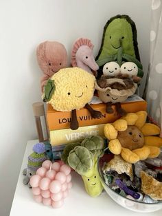 a pile of stuffed animals sitting on top of each other next to books and balloons