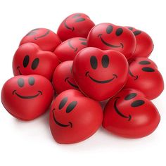 a pile of red heart shaped balloons with faces drawn on them