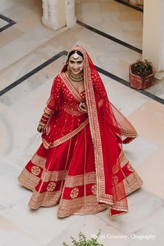 a woman in a red and gold bridal gown