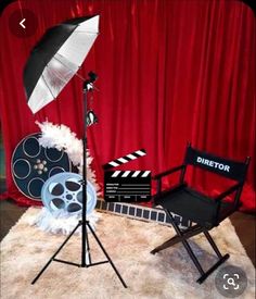 a chair and umbrella sitting on top of a white rug next to a red curtain