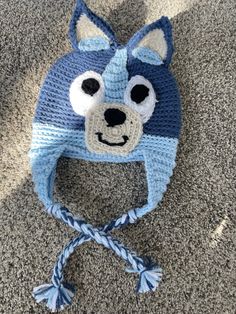 a crocheted blue and white hat with a dog face on it's side