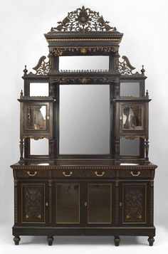 an ornate wooden cabinet with mirror on it's top and two doors open to the side