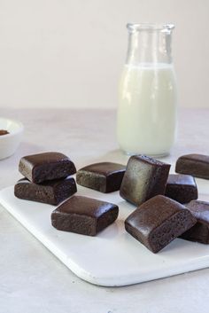 chocolate brownies on a cutting board next to a glass of milk