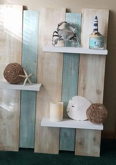 two shelves made out of wooden boards with seashells and candles on each shelf