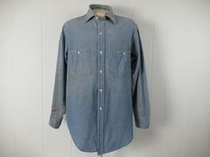 "Vintage 1950s work shirt, painter's shirt, workwear. Made of blue chambray cotton. Has a button down front, button cuffs, white buttons and two pockets. Made by Penney's Big Mac. About a size large. Actual measurements are: 47\" at the chest 47\" at the waist 18\" shoulder seam to shoulder seam 24.5\" shoulder seam to cuff 33\" overall length In very good condition." 1950s Shirts, Workwear Vintage, Vintage Workwear, Big Mac, Work Shirt, Chambray Shirt, Mens Oxfords, Vintage Shirt, Work Shirts