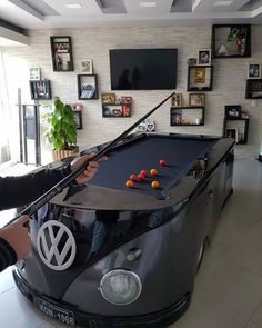 a man is playing pool in a vw bus