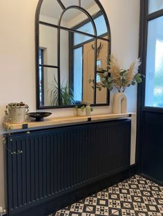 a black and white tiled floor in front of a wall with a mirror on it