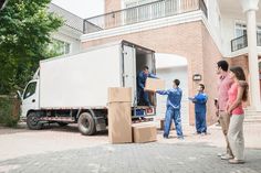 three people unloading boxes from the back of a moving truck