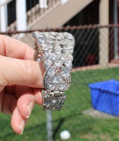 Stunning art deco style clamper bracelet! It is an intricate silver tone metal design with large rhinestone. Tiny silver metal beads surround the rhinestones and the back has a criss cross design. I love how the back also has a beautiful design and rhinestones. It is oval and hinged on the side. No makers mark. So reminiscent of the flapper era. Although this may be considered jewelry for formal wear, I think it would be so cool with jeans. It is in great vintage condition, no loss of rhinestone Glamorous Silver Crystal Bracelet, Glamorous Silver Cuff Bracelet With Rhinestones, Silver Metal Crystal Bracelet With Jewels, Formal Silver Jeweled Bracelet, Silver Jeweled Bracelet For Formal Occasions, Glamorous Silver Jeweled Crystal Bracelet, Glamorous Silver Bangle For Formal Occasions, Silver Jeweled Crystal Bracelet With Cubic Zirconia, Silver Jeweled Bracelet With Cubic Zirconia