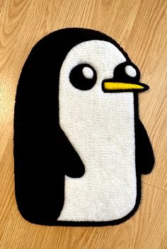 a black and white penguin rug sitting on top of a wooden floor