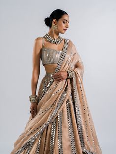 Editor's Note Featuring a beige real hand cut mirror seam lehenga set paired with a heavily embellished linear draped blouse and dupatta Fabric: Lehenga: satin organza, blouse: georgette, dupatta :satin organza Color: Beige Component: Lehenga, blouse and dupatta Sleeve type: Sleeveless Occasion: Sangeet Care: Dry Clean Only About the Designer Vvani by Vani Vats- an Indian ethnic women’s wear label. It is a depiction of the royal and intricate handcrafted embroideries in unconventional designs. Black Indian Outfit, Beige Mirror, Mirror Blouse, Vani Vats, Gold Lehenga, Lehenga Dupatta, Full Sleeve Blouse, Georgette Dupatta, Organza Blouse