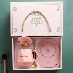 a pink tea set in a box with gold trimmings on the top and bottom