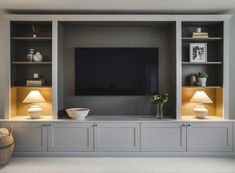 an entertainment center with built - in shelving and lamps