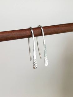 These hammered silver drop earrings will go with anything they are very lightweight and comfortable to wear, made from sterling silver and hand forged from a length of solid 925 sterling silver wire. They are made using a traditional method called planishing which flattens and smooths out the silver, before the hammered finish. This process also hardens the silver, making them tough but also very lightweight and comfortable to wear. They have a hammered finish to catch the light, and are polished to a high shine. Each pair that I make are hand-forged and completely individual. Please note Earrings are non returnable for hygiene reasons Choice of Length 2.5 cm (1 inch)   3.5 cm (1.4 inch)          Silver wire width 0.9mm (US 19 Gauge) we recommend the use of Silicone backs for older/ stretc Hammered Jewelry, Handmade Silver Jewellery, Stick Earrings, Silver Earrings Handmade, Sterling Silver Drop Earrings, Hammered Sterling Silver, Wedding Jewelry Earrings, 925 Silver Earrings, Silver Jewelry Handmade