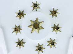 several brass stars are arranged on a white surface