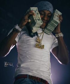 a man holding up stacks of money in his hands