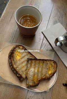 two pieces of grilled meat on a plate next to a cup of coffee