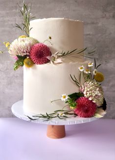 a three layer cake with flowers on top