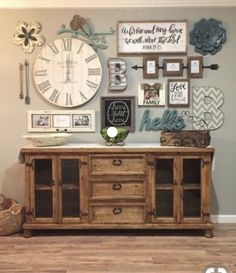 a living room with a large clock and pictures on the wall next to a wooden cabinet