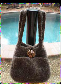 a brown purse sitting next to a pool