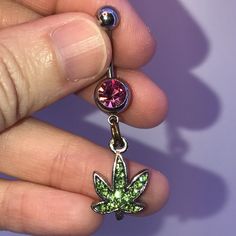 These Are 316-L Stainless Steel Belly Ring With A Dangle Of A Pot Leaf Design. The Ring In The Middle Is A Split Or Spring Ring. It's Designed This Way So Your Charm Stays On Your Belly Ring. Green Rhinestone Leaf With Medium Pink Top Gold Split Ring If You Want A Different Color Belly Ring Let Me Know I Can Change Them Out. This Is A Standard 14 Gauge Belly Ring. The Top Gem Changes From One Belly Ring To Another But The Bottom Stays The Same. It Is A Peridot Green Rhinestone Pot Leaf That Is M Adjustable Pink Jeweled Jewelry, Pink Metal Jewelry With Bling, Pink Bling Metal Jewelry, Adjustable Pink Body Jewelry For Gift, Pink Jeweled Metal Jewelry, Adjustable Nickel-free Pink Belly Rings, Cute Belly Rings Dangle, Cute Belly Rings, Dangle Belly Rings