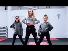 three girls in grey sweaters and black pants are posing for the camera with their hands on their hips