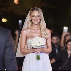 a woman in a wedding dress holding a bouquet