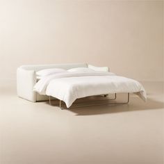 a bed that is sitting in the middle of a room with white sheets on it