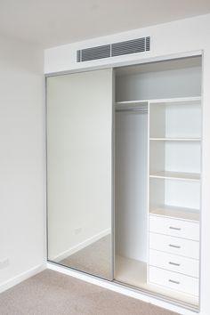 an empty white closet with drawers and shelves