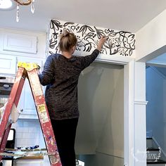 a woman standing on top of a step ladder