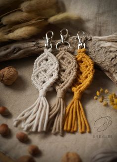 three crocheted tassels are sitting on a piece of fabric next to some nuts