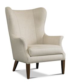 an upholstered wingback chair with dark wood legs and beige fabric, on a white background