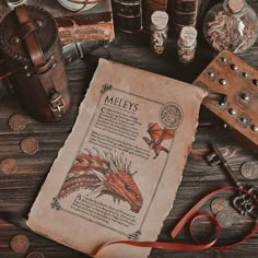 an old book sitting on top of a wooden table next to other antique items and coins