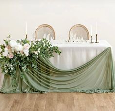 the table is covered with green cloth and flowers