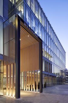 the entrance to an office building lit up at night with lights shining on it's windows