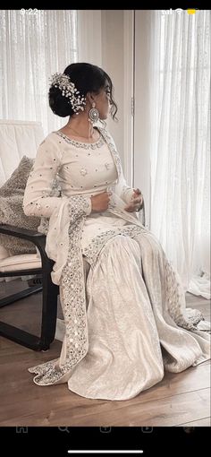 a woman in a white dress sitting on a chair