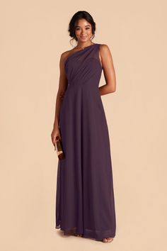 a woman in a long purple dress with one shoulder draped over her shoulders and an open back