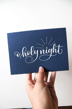 someone holding up a card with the word holly night written on it in white ink