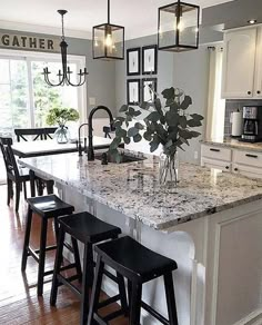 a kitchen island with marble counter tops and stools