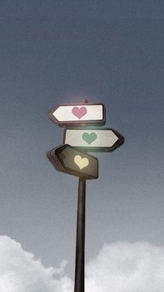 a street sign with hearts on it and two arrows pointing in opposite directions against a cloudy sky