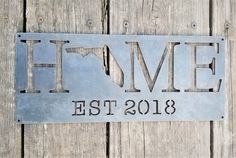 a metal sign that reads, home est 2018 on the side of a wooden fence