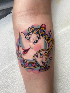 a small tattoo on the leg of a woman with an elephant and princess face in it