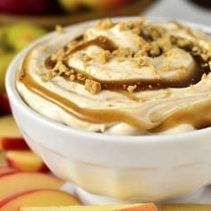 a bowl filled with ice cream and caramel toppings on top of an apple