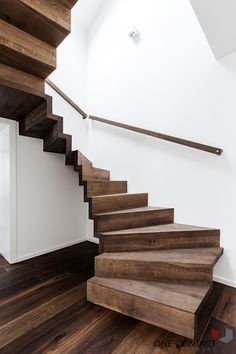 a wooden staircase with white walls and wood flooring