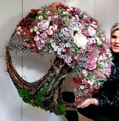 a woman sitting on a chair holding a large floral arrangement